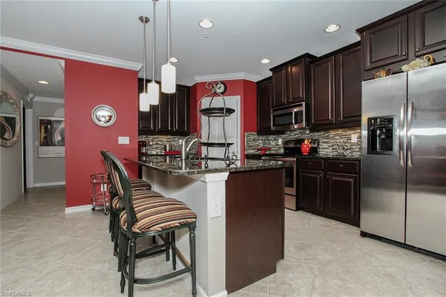 a kitchen with stainless steel appliances granite countertop a stove refrigerator and a sink