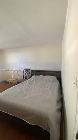 a bed sitting in a bedroom next to a window