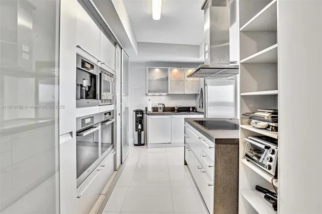 a kitchen with stainless steel appliances granite countertop a refrigerator and a stove