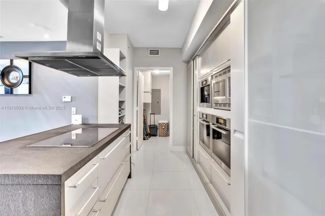 a kitchen with granite countertop a sink and refrigerator