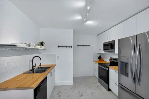 a kitchen with stainless steel appliances granite countertop a sink a stove and a refrigerator