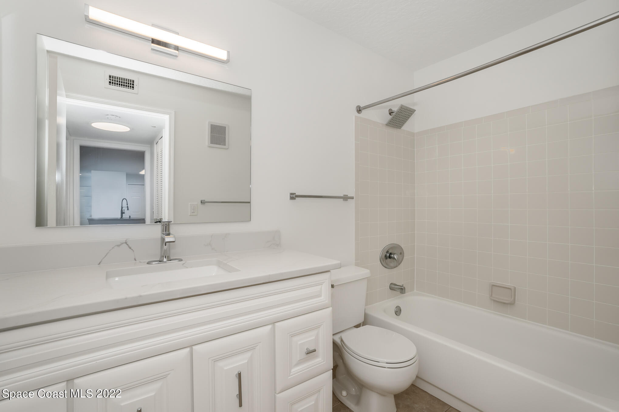 7667 North Wickham Road, Unit 113 Melbourne, FL 32940 - Photo 18 of 29 a bathroom with a sink a toilet and a mirror