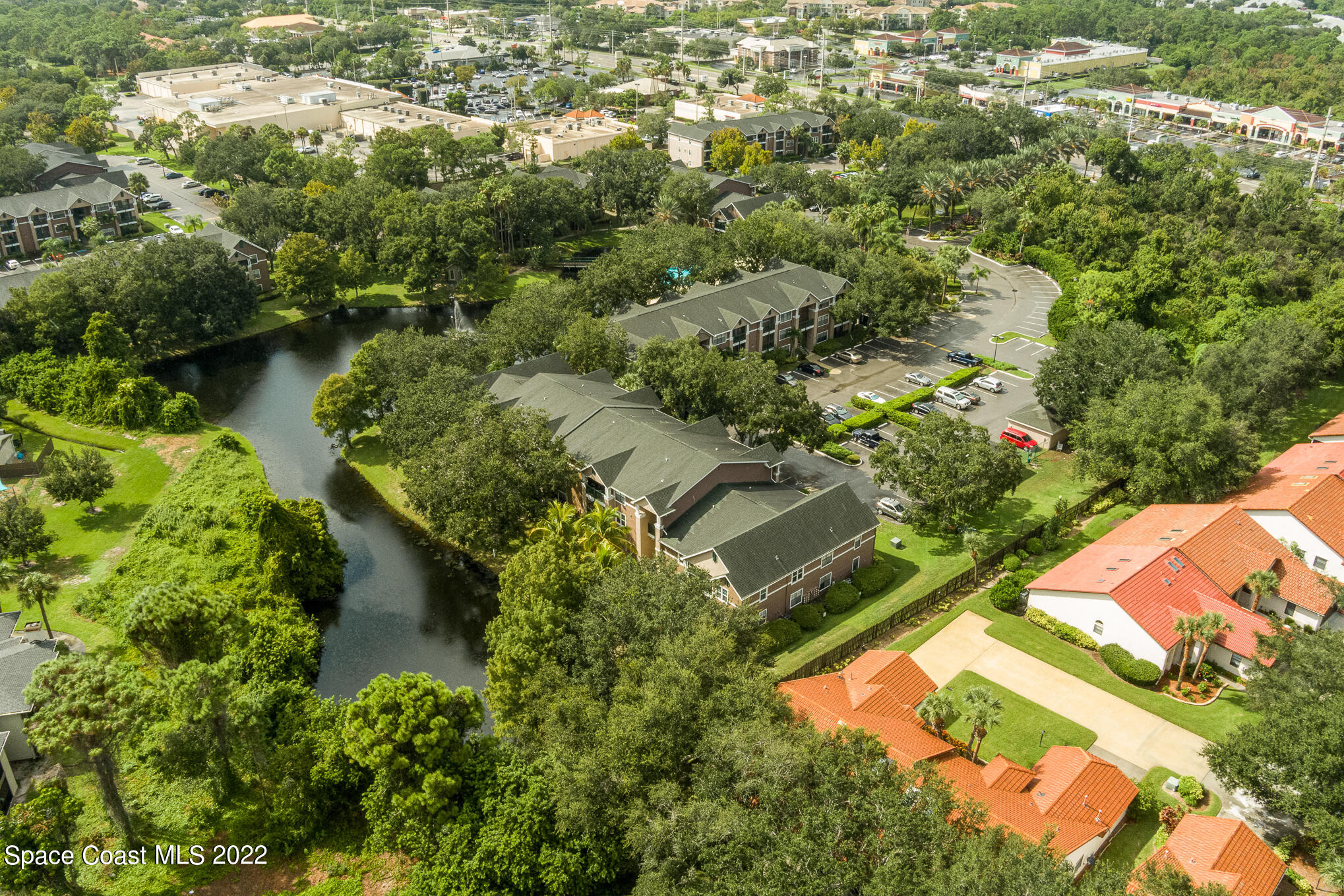 7667 North Wickham Road, Unit 113 Melbourne, FL 32940 - Photo 28 of 29 an aerial view of residential houses with outdoor space and trees