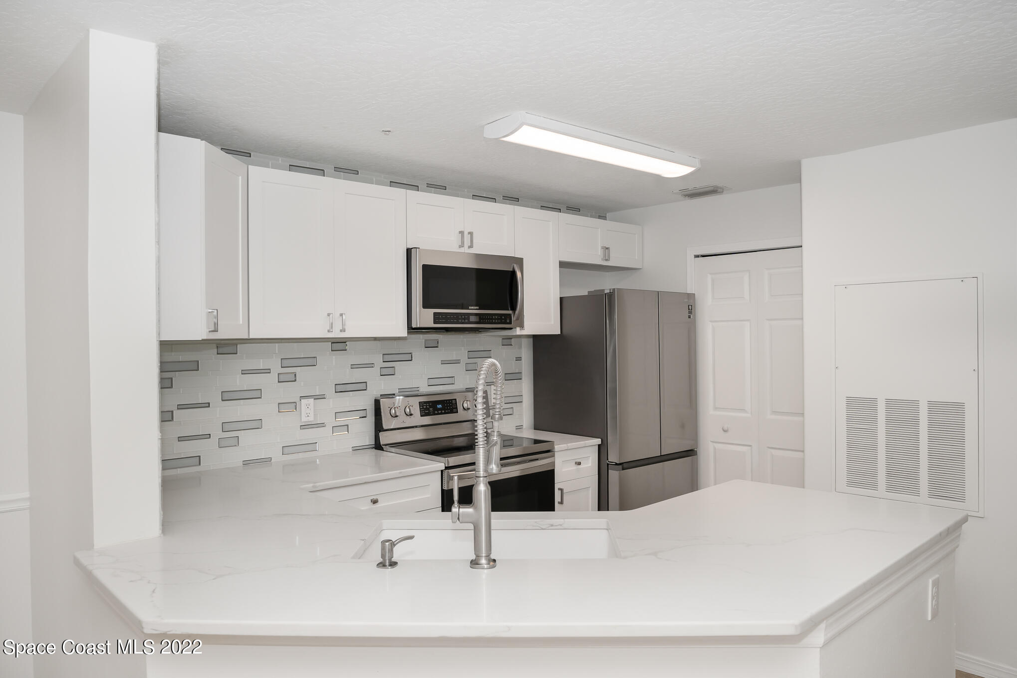 7667 North Wickham Road, Unit 113 Melbourne, FL 32940 - Photo 4 of 29 a kitchen with stainless steel appliances a microwave and sink