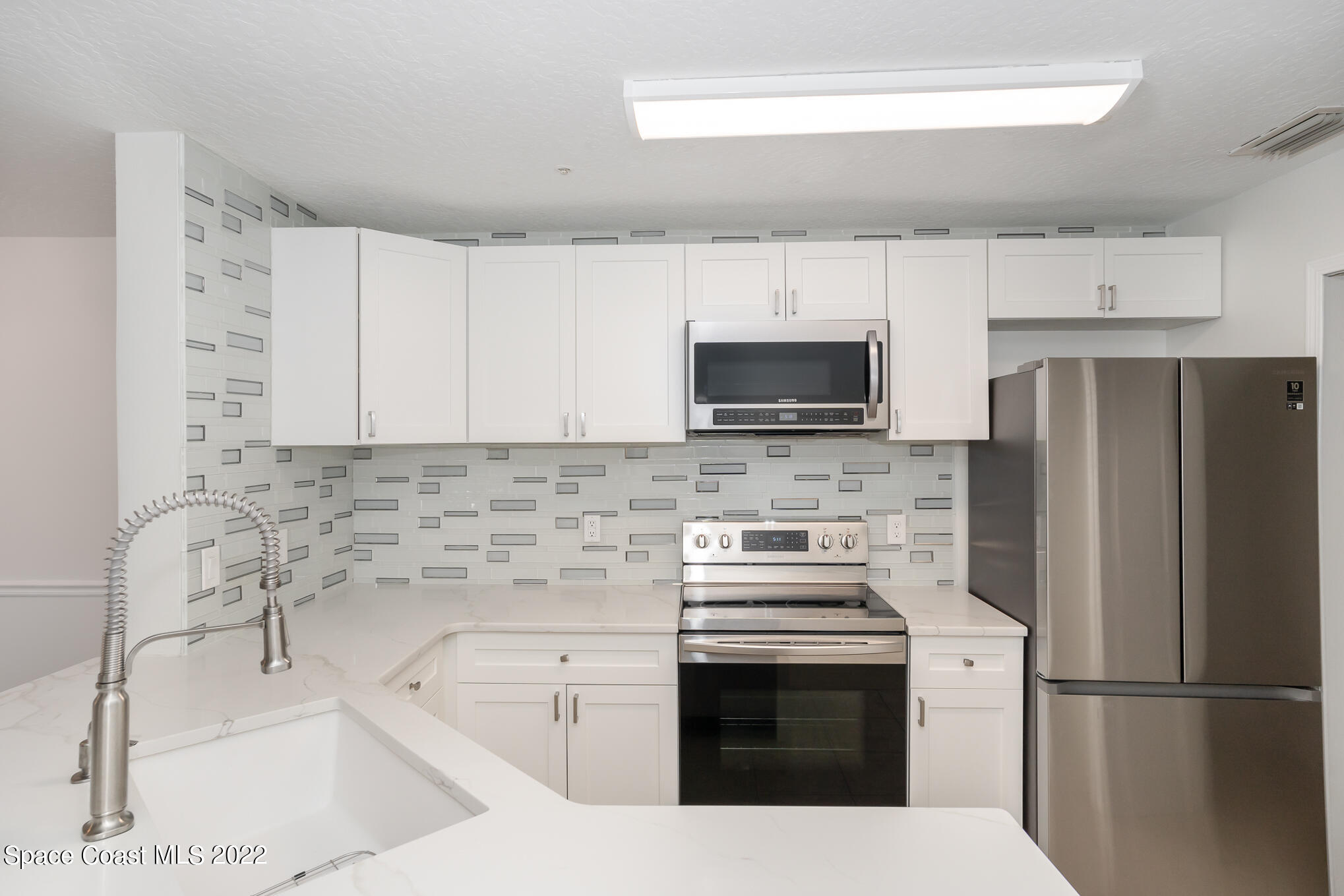 7667 North Wickham Road, Unit 113 Melbourne, FL 32940 - Photo 5 of 29 a kitchen with a sink stove and refrigerator