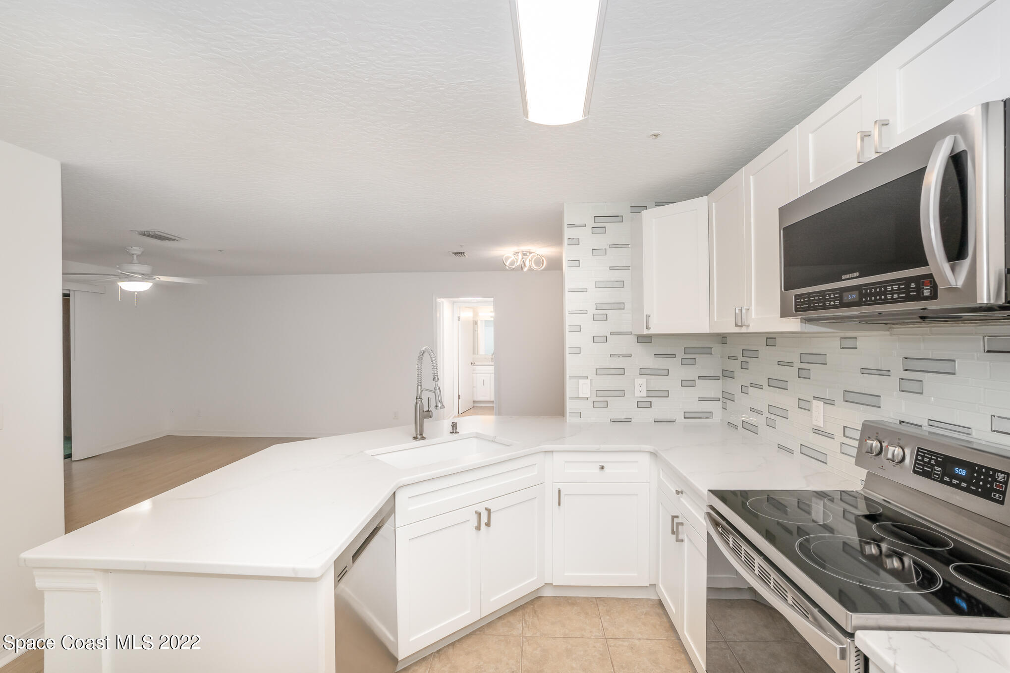 7667 North Wickham Road, Unit 113 Melbourne, FL 32940 - Photo 6 of 29 a kitchen with a sink stove and microwave