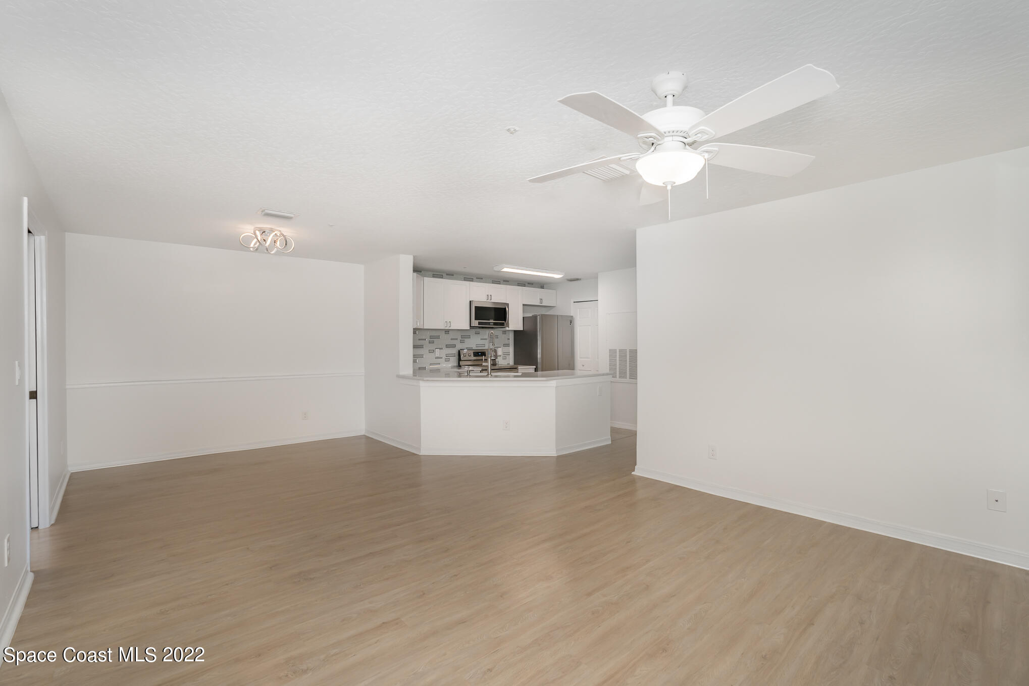 7667 North Wickham Road, Unit 113 Melbourne, FL 32940 - Photo 8 of 29 a view of a kitchen with a sink and a chandelier fan