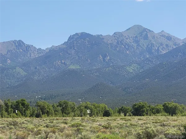 a view of a dry yard with mountains in the background