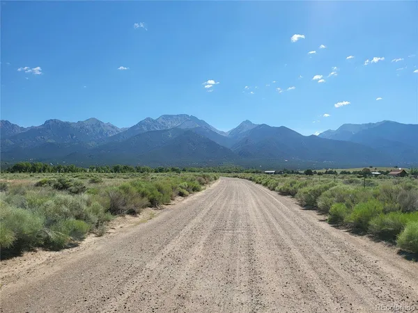 a view of a dry yard with mountains in the background