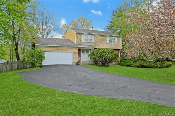 a front view of house with yard and green space