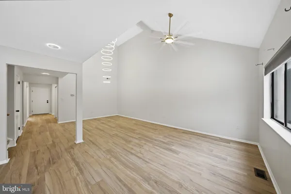 a view of a hallway with wooden floor and entryway
