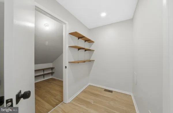 a view of a room with wooden floor and small racks