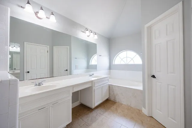 a spacious bathroom with a sink mirror and a bathtub