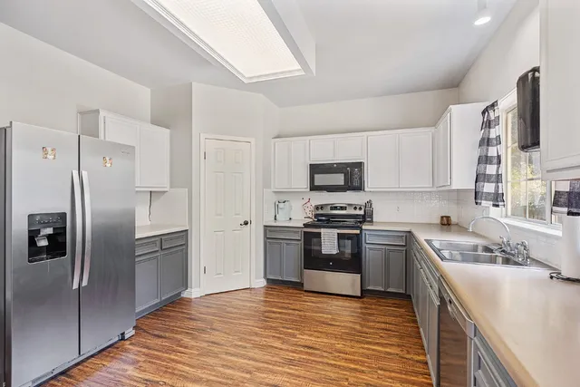 a kitchen with stainless steel appliances granite countertop a refrigerator stove and sink