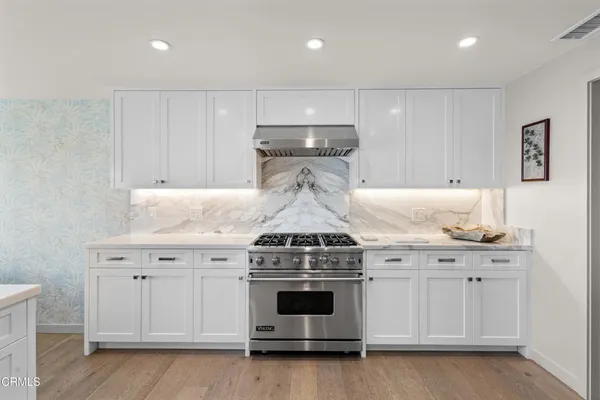 a kitchen with stainless steel appliances granite countertop a refrigerator and a stove top oven