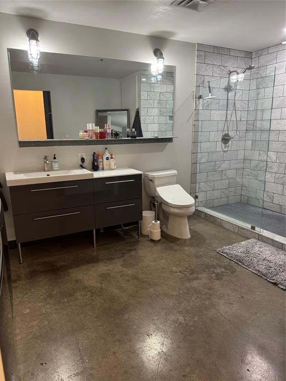 1122 Jackson Street, Unit 303 Dallas, TX 75202 - Photo 14 of 18 a bathroom with a toilet a sink and mirror