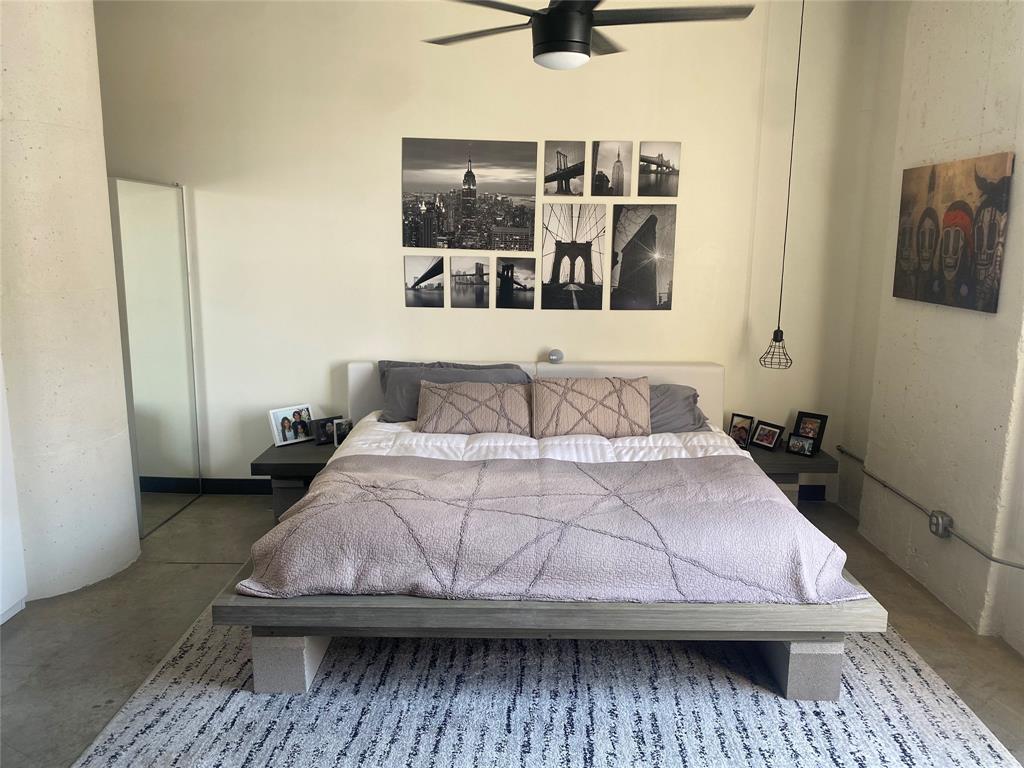 1122 Jackson Street, Unit 303 Dallas, TX 75202 - Photo 2 of 18 a bedroom with a bed and wooden floor