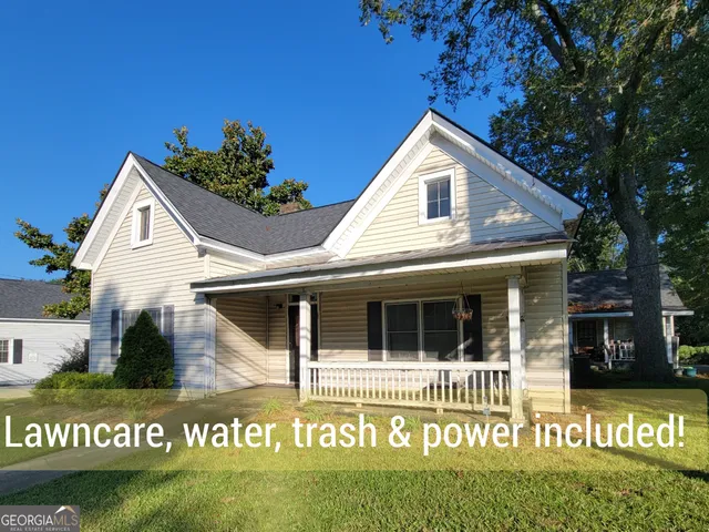 a view of house with sign board and yard