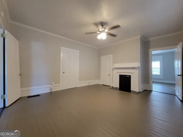 a view of empty room with wooden floor and fireplace
