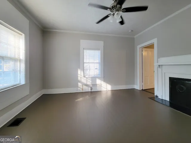an empty room with windows and fireplace