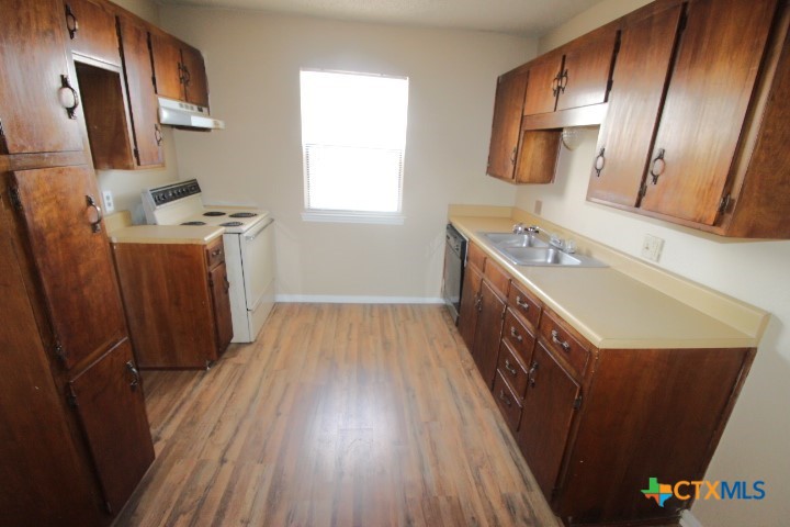 304 Erby Avenue, Unit C Copperas Cove, TX 76522 - Photo 2 of 9 a kitchen with wooden floors and a sink