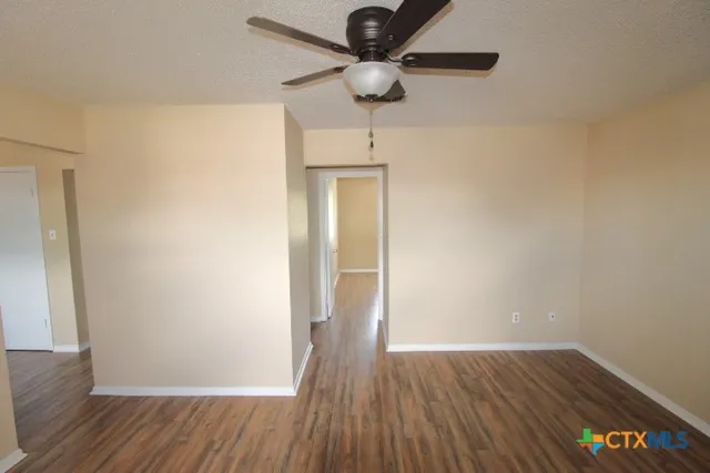 a view of an empty room with wooden floor