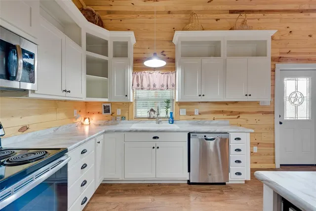 a kitchen with white cabinets and sink
