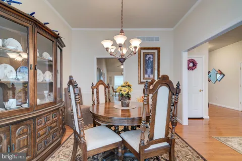 a kitchen with stainless steel appliances granite countertop a dining table and chairs with wooden floor