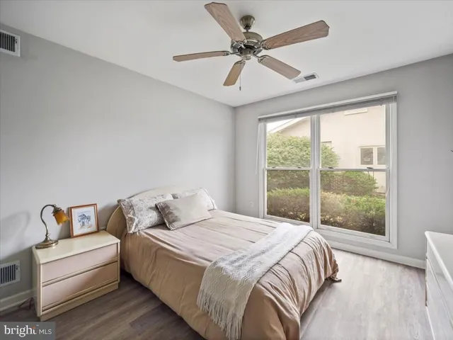 a bedroom with a bed wooden floor and window