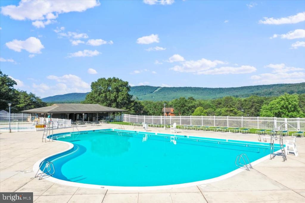 169 Arrowhead Loop Hedgesville, WV 25427 - Photo 19 of 24 a view of a swimming pool with lawn chairs under an umbrella