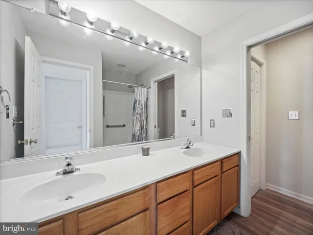 a bathroom with double vanity sinks and a mirror