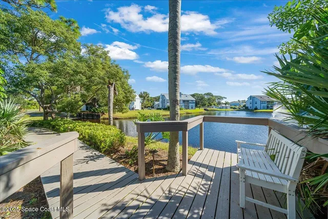 a view of a balcony with a table and chairs and wooden fence