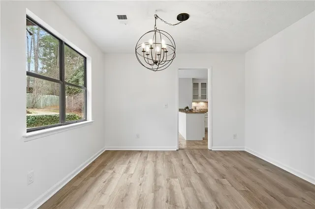 an empty space with wooden floor and a window