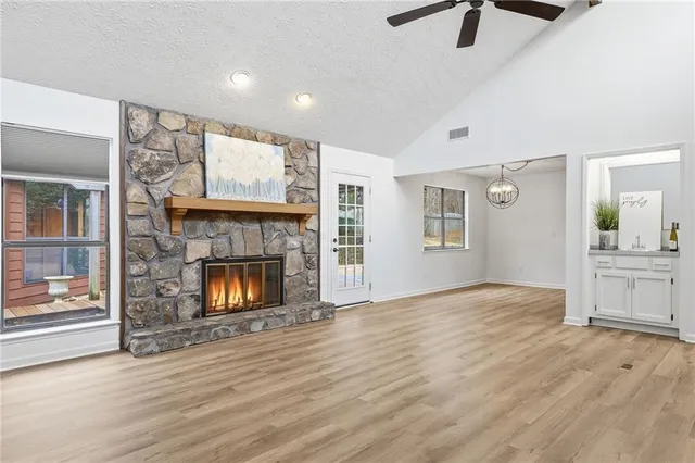 an empty room with windows and fireplace