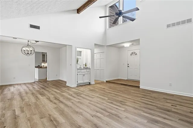 a view of empty room with wooden floor and ceiling fan