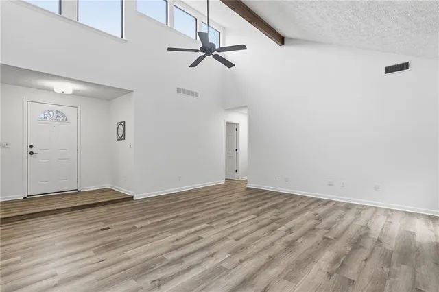 a view of an empty room with wooden floor