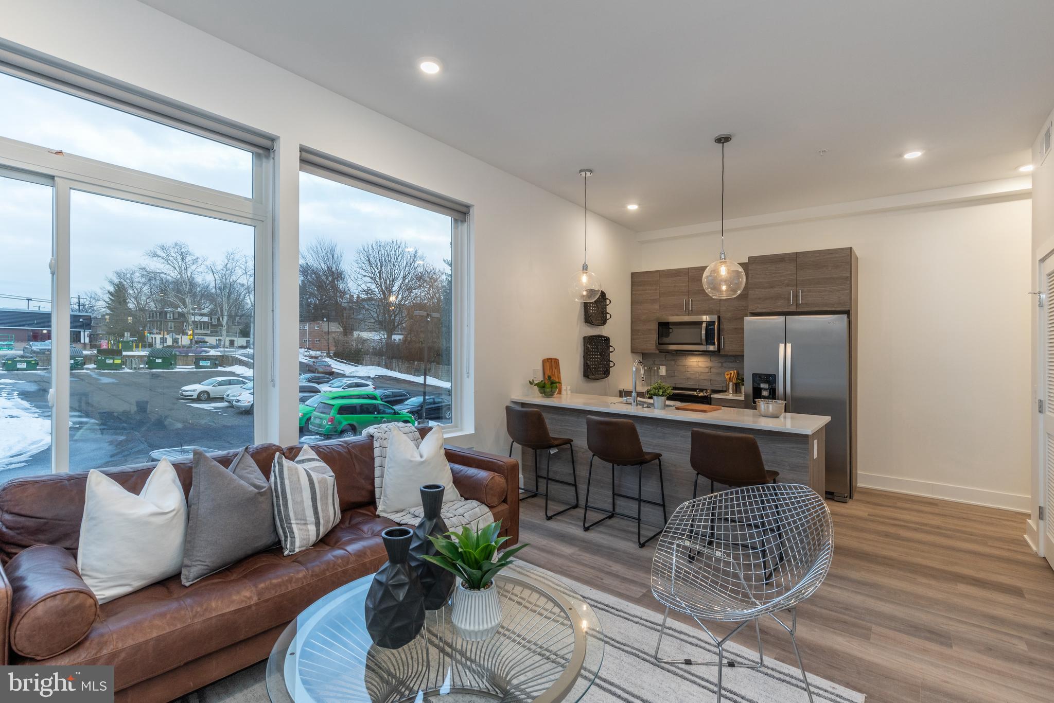 a living room with furniture a wooden floor and a large window