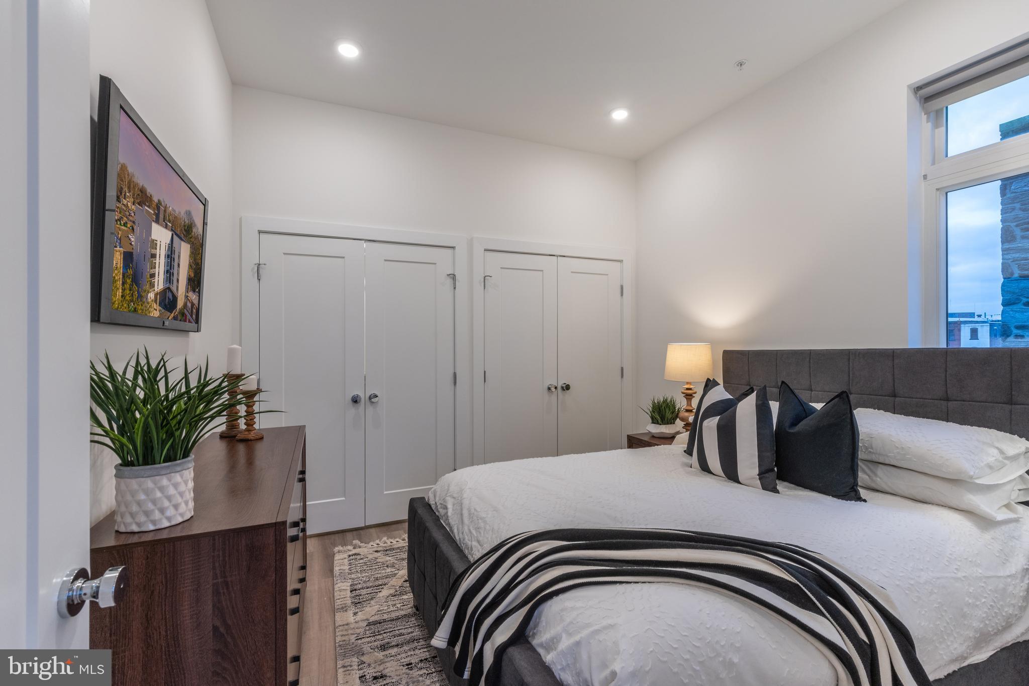 5545 Pulaski Avenue, Unit 401 Philadelphia, PA 19144 - Photo 13 of 16 a bedroom with a bed and a potted plant