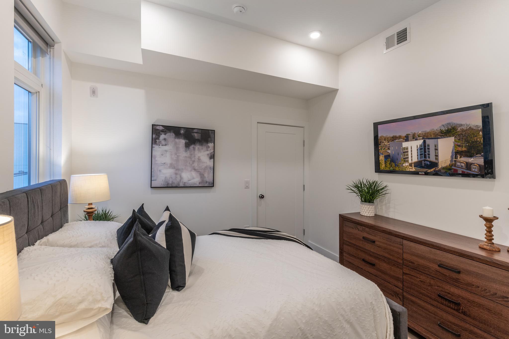 5545 Pulaski Avenue, Unit 401 Philadelphia, PA 19144 - Photo 15 of 16 a bedroom with a bed and a painting on the wall