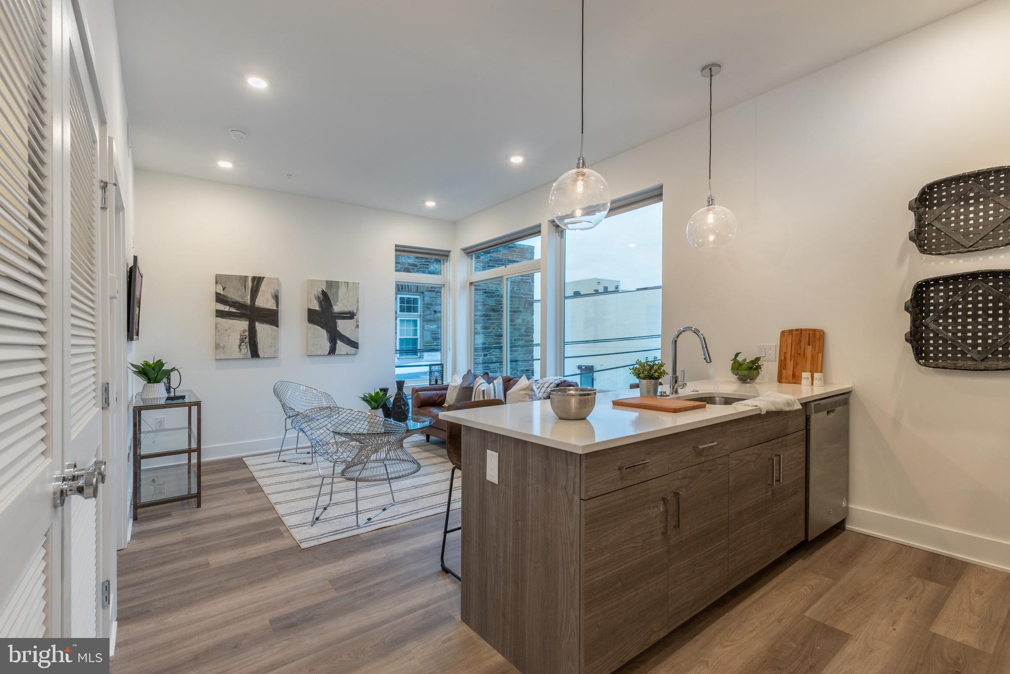 5545 Pulaski Avenue, Unit 401 Philadelphia, PA 19144 - Photo 4 of 16 a view of a kitchen counter top space with granite countertop wooden floor and living room view