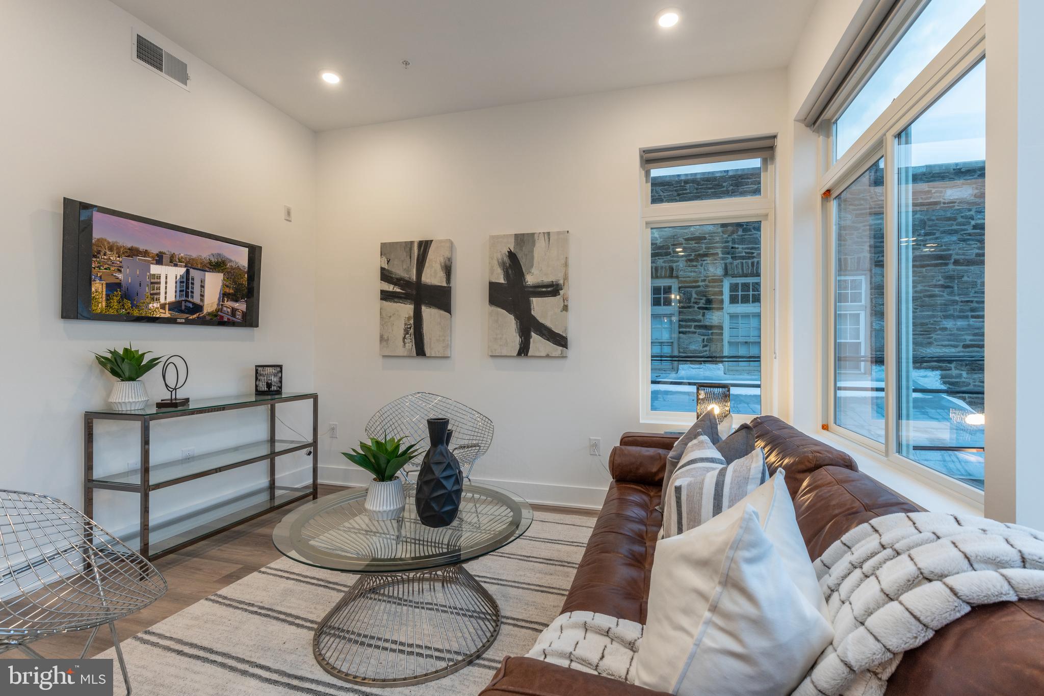 5545 Pulaski Avenue, Unit 401 Philadelphia, PA 19144 - Photo 9 of 16 a living room with furniture potted plant and a large window