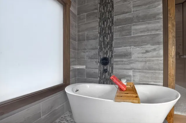 a white bath tub sitting in a bathroom next to a sink