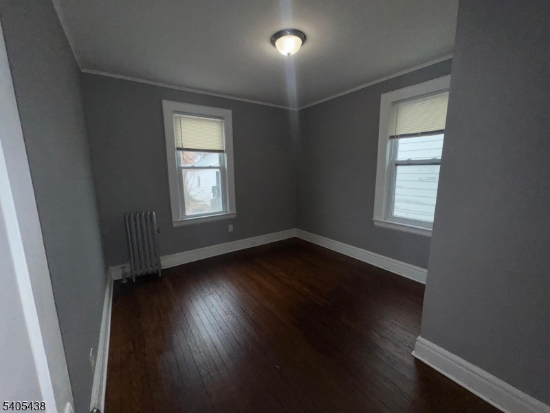 742 Pennington Street Elizabeth, NJ 07202 - Photo 2 of 11 an empty room with wooden floor and windows