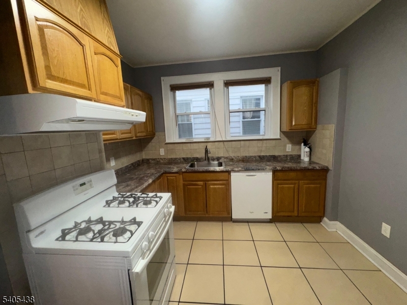 742 Pennington Street Elizabeth, NJ 07202 - Photo 6 of 11 a kitchen with a stove a sink and a refrigerator