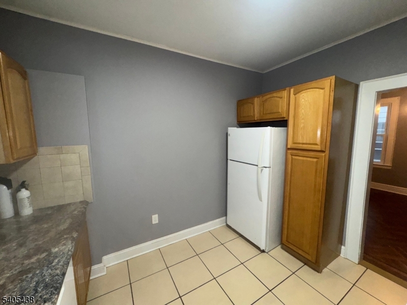742 Pennington Street Elizabeth, NJ 07202 - Photo 9 of 11 a view of a refrigerator in kitchen and an empty room