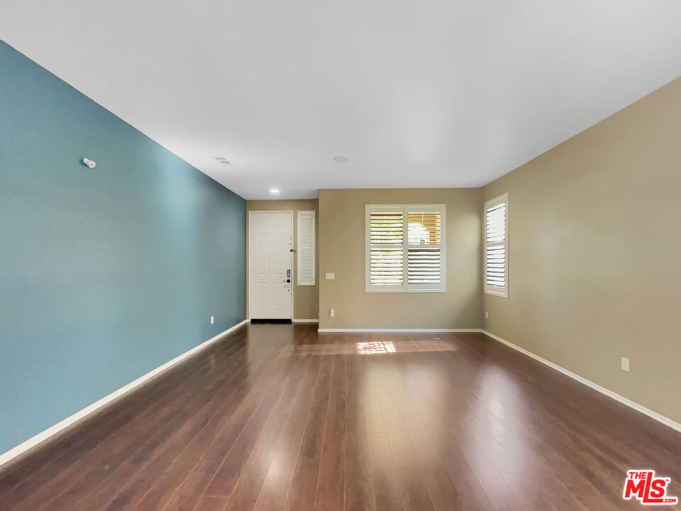 24025 Via Sereno Valencia, CA 91354 - Photo 12 of 27 a view of an empty room with wooden floor and windows