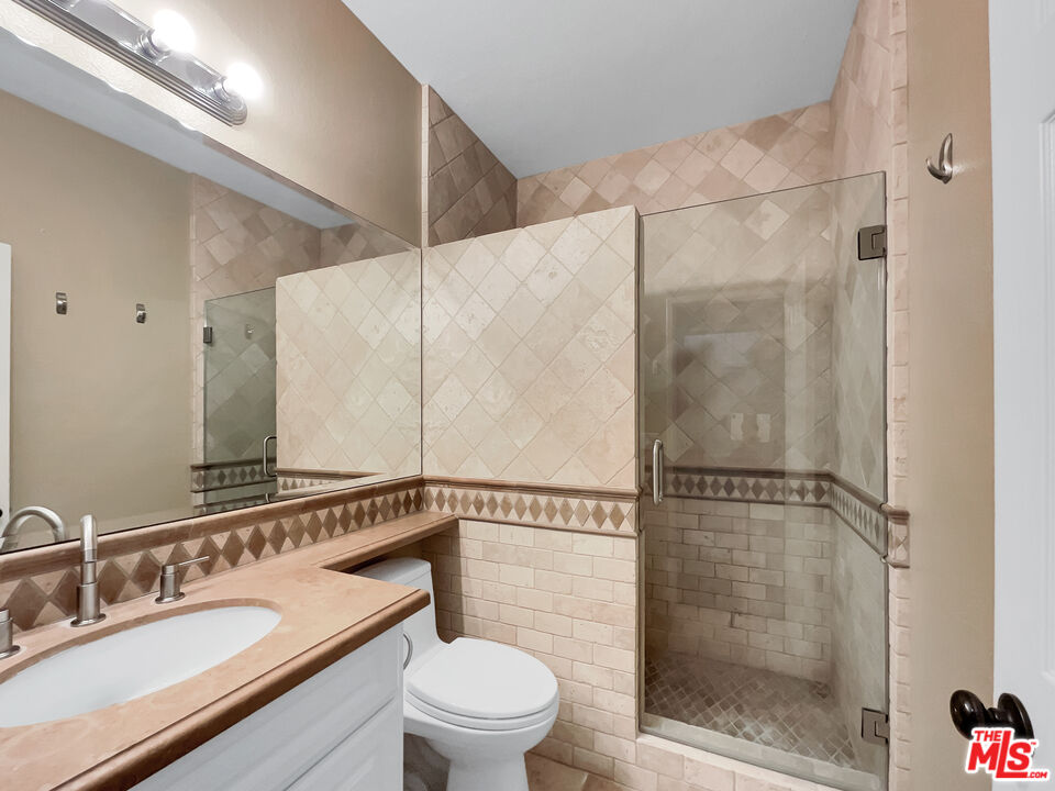 24025 Via Sereno Valencia, CA 91354 - Photo 18 of 27 a bathroom with a shower sink mirror and toilet
