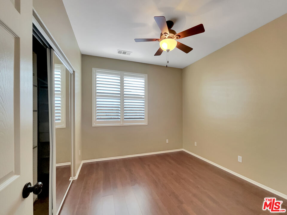 24025 Via Sereno Valencia, CA 91354 - Photo 20 of 27 a view of an empty room with wooden floor and a ceiling fan