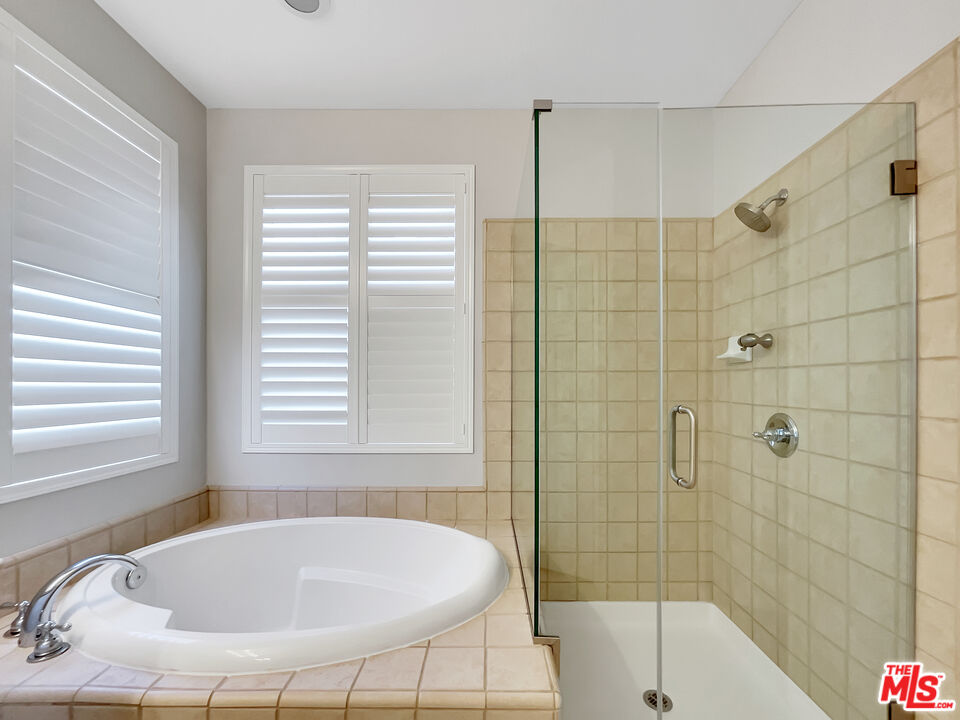 24025 Via Sereno Valencia, CA 91354 - Photo 23 of 27 a bathroom with a tub and a shower