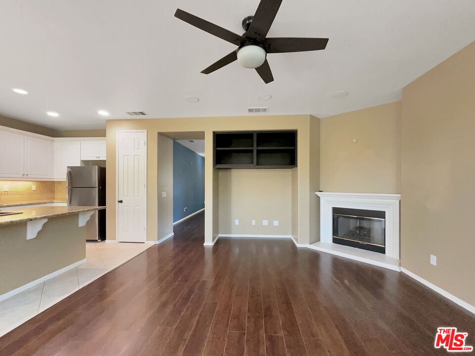 24025 Via Sereno Valencia, CA 91354 - Photo 3 of 27 a view of a livingroom with a fireplace a ceiling fan and wooden floor